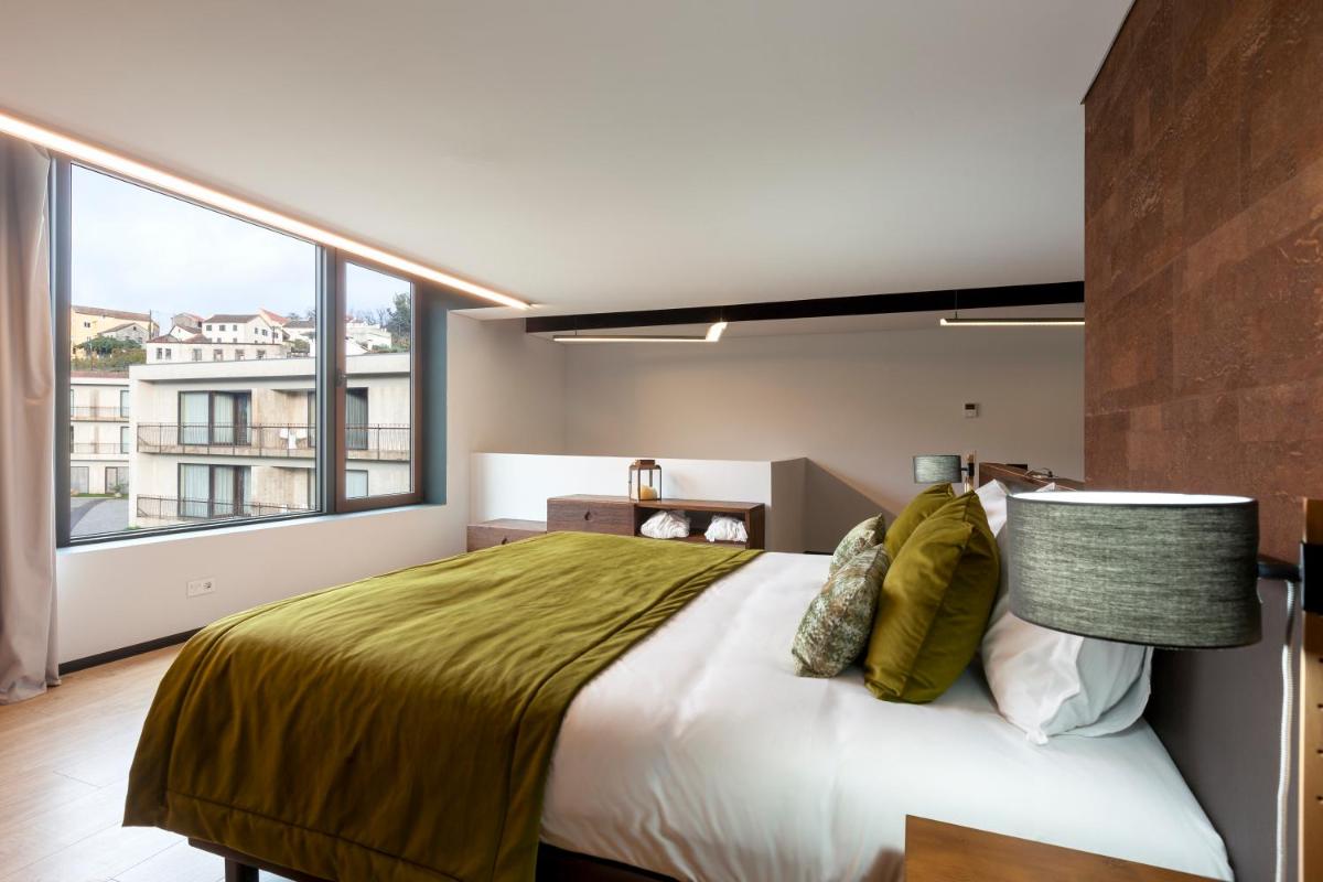 um quarto com uma cama grande e uma janela grande em Aqua Village, Health Resort em Oliveira do Hospital