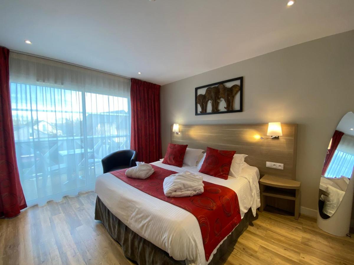 Un ou plusieurs lits dans un hébergement de l'établissement Contact hôtel - Hôtel Les Bleuets & SPA