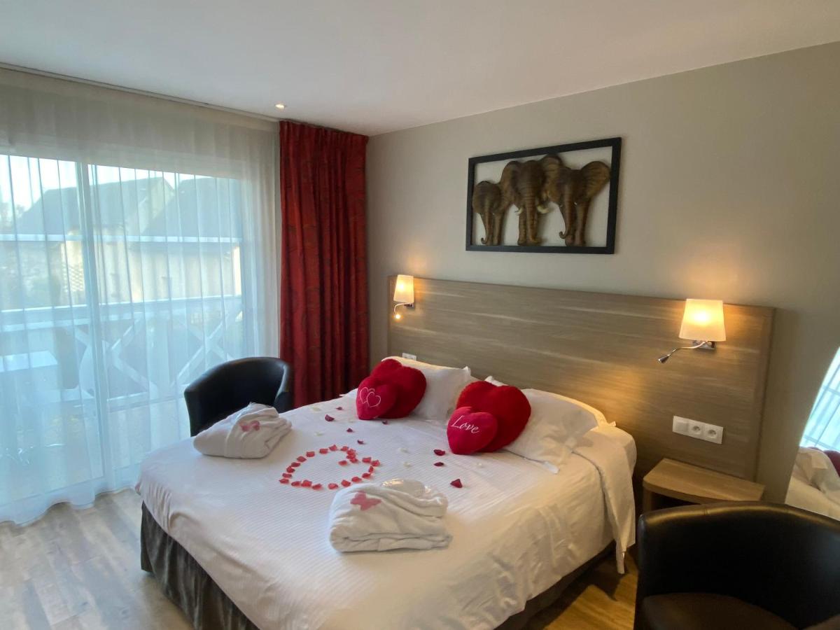 Un ou plusieurs lits dans un hébergement de l'établissement Contact hôtel - Hôtel Les Bleuets & SPA