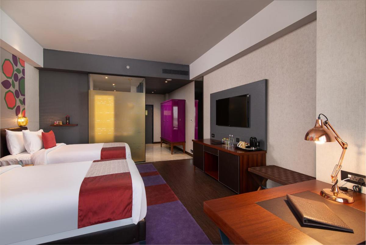 a hotel room with a bed and a desk and a tv at Grand Mercure Bengaluru at Gopalan Mall - An Accor Brand in Bengaluru a hotel room with a bed and a desk and a tv at Grand Mercure Bengaluru at Gopalan Mall - An Accor Brand in Bengaluru