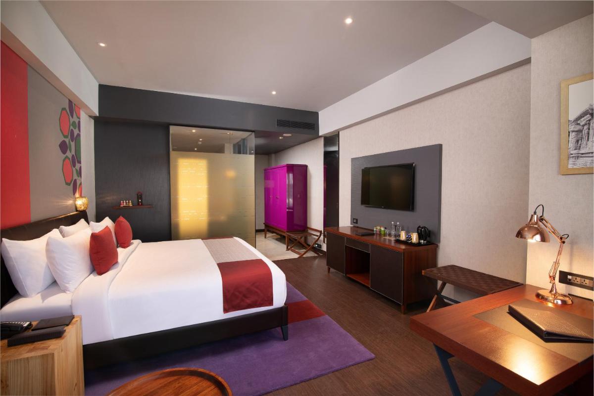 a bedroom with a bed and a desk and a television at Grand Mercure Bengaluru at Gopalan Mall - An Accor Brand in Bengaluru a bedroom with a bed and a desk and a television at Grand Mercure Bengaluru at Gopalan Mall - An Accor Brand in Bengaluru