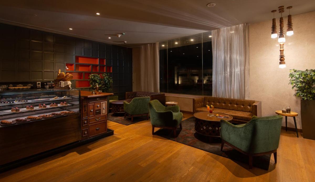 a restaurant with chairs and a table and a counter at Grand Mercure Bengaluru at Gopalan Mall - An Accor Brand in Bengaluru a restaurant with chairs and a table and a counter at Grand Mercure Bengaluru at Gopalan Mall - An Accor Brand in Bengaluru