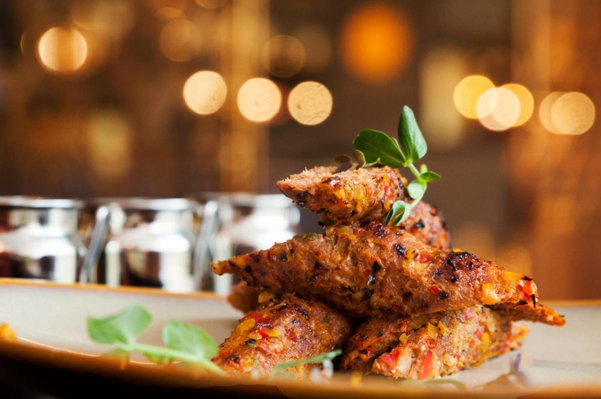 a pile of food on a plate on a table at Grand Mercure Bengaluru at Gopalan Mall - An Accor Brand in Bengaluru a pile of food on a plate on a table at Grand Mercure Bengaluru at Gopalan Mall - An Accor Brand in Bengaluru