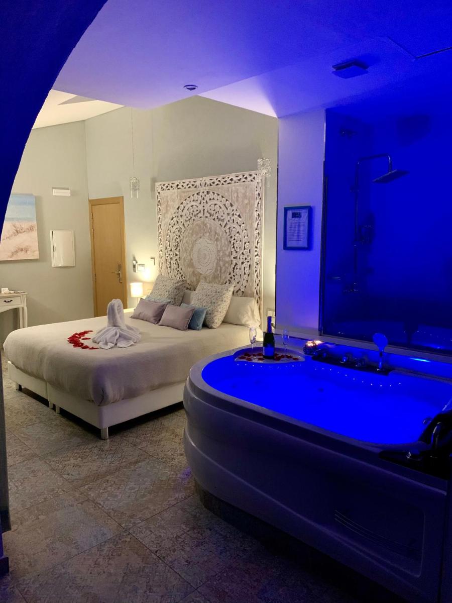 Un dormitorio con una cama y una bañera en una habitación. en Akla Hotel Mérida, en Mérida