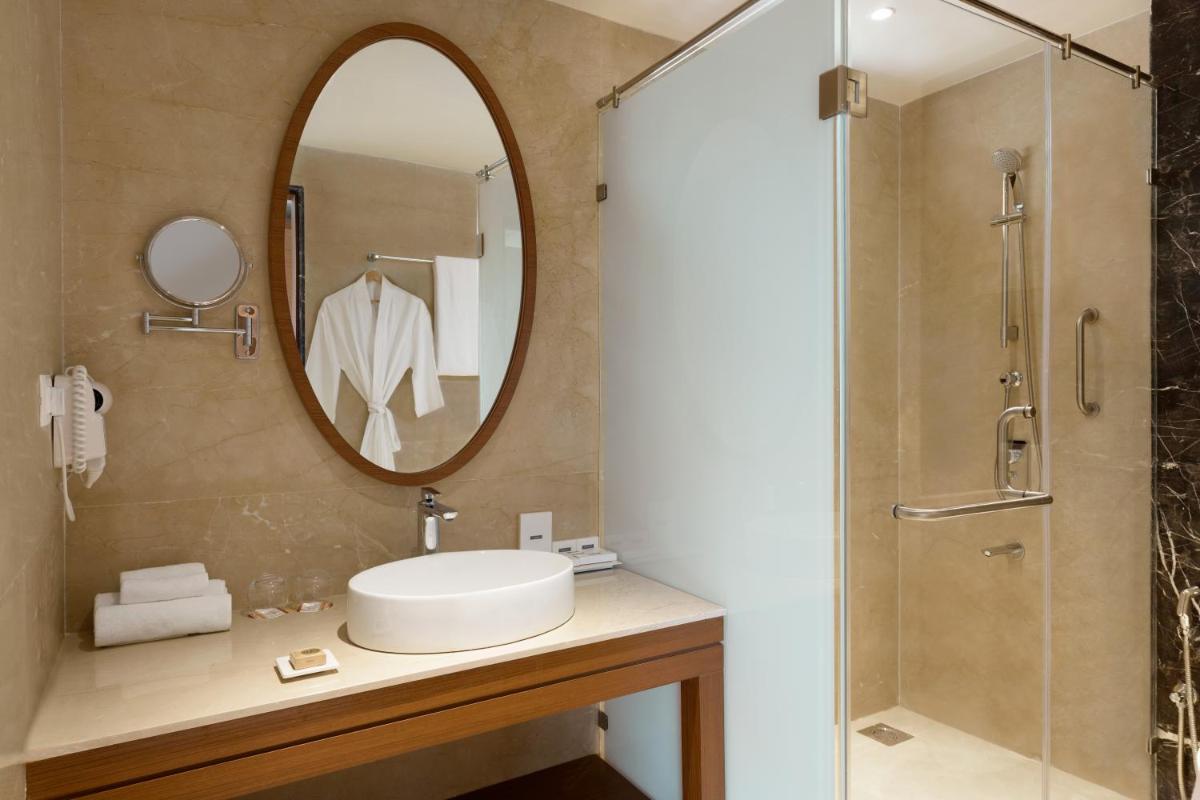 a bathroom with a sink and a mirror at Hawthorn Suites by Wyndham Dwarka in Dwarka a bathroom with a sink and a mirror at Hawthorn Suites by Wyndham Dwarka in Dwarka