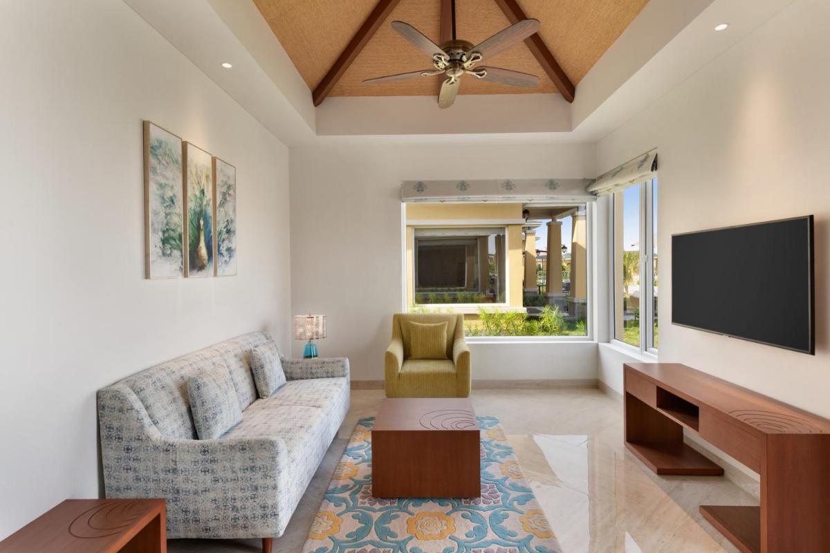 a living room with a couch and a flat screen tv at Hawthorn Suites by Wyndham Dwarka in Dwarka a living room with a couch and a flat screen tv at Hawthorn Suites by Wyndham Dwarka in Dwarka