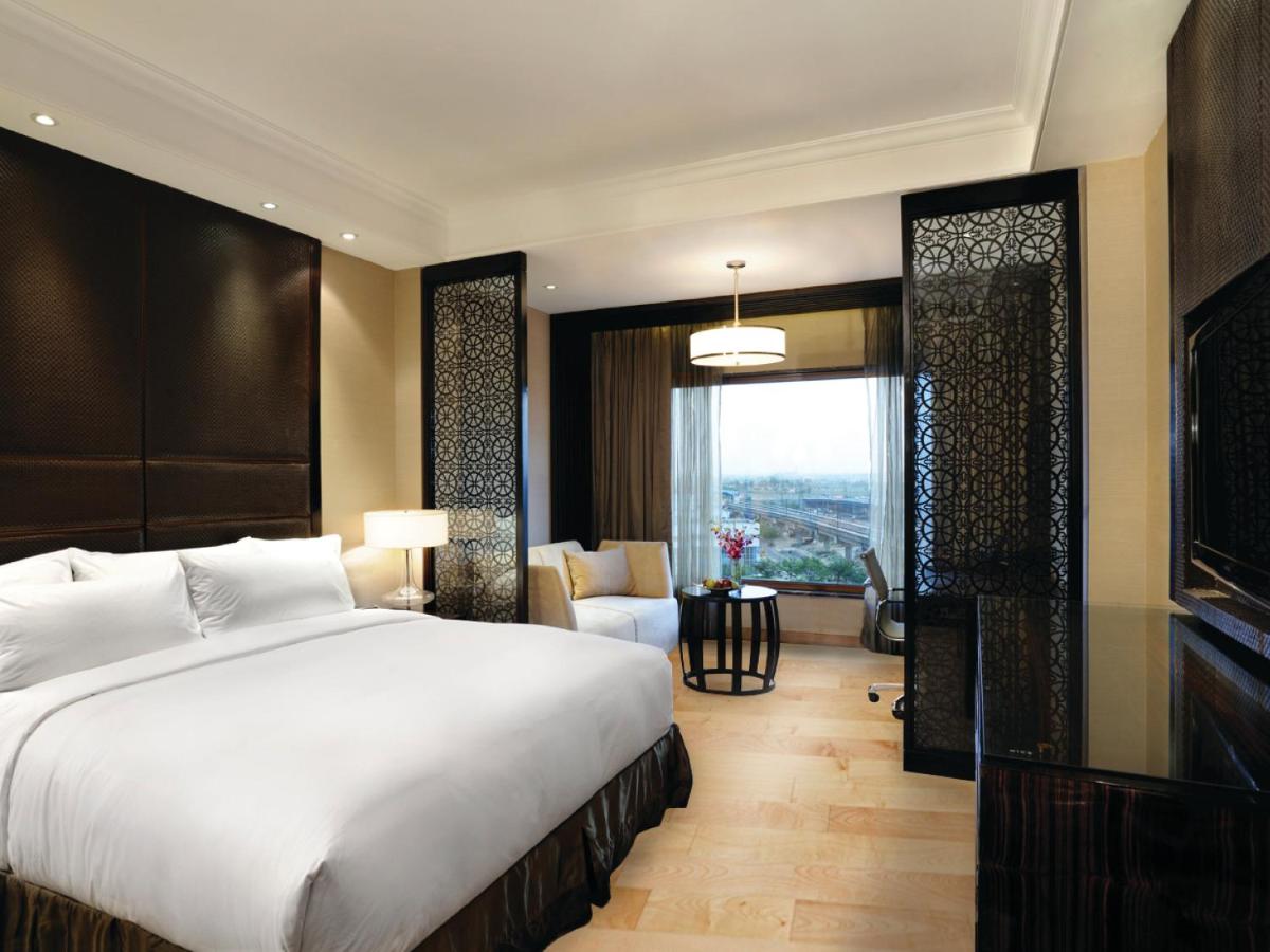 a bedroom with a large bed and a large window at Crowne Plaza New Delhi Mayur Vihar Noida by IHG in New Delhi