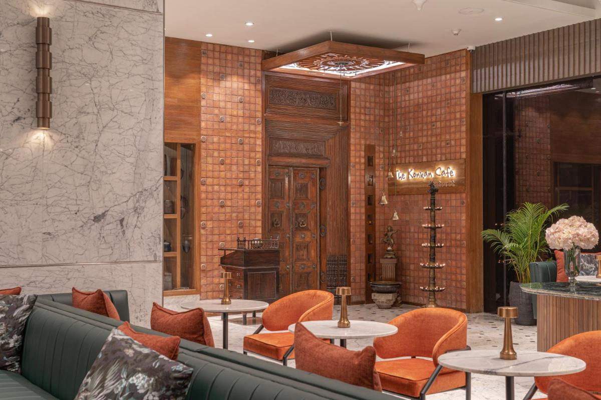 a lobby with tables and chairs and a piano at President - IHCL SeleQtions in Mumbai