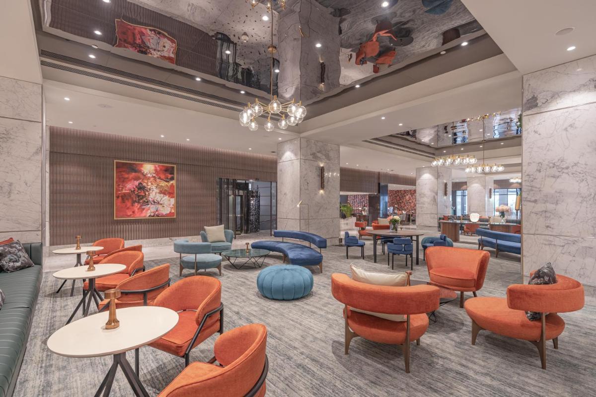 a lobby of a hotel with tables and chairs at President - IHCL SeleQtions in Mumbai