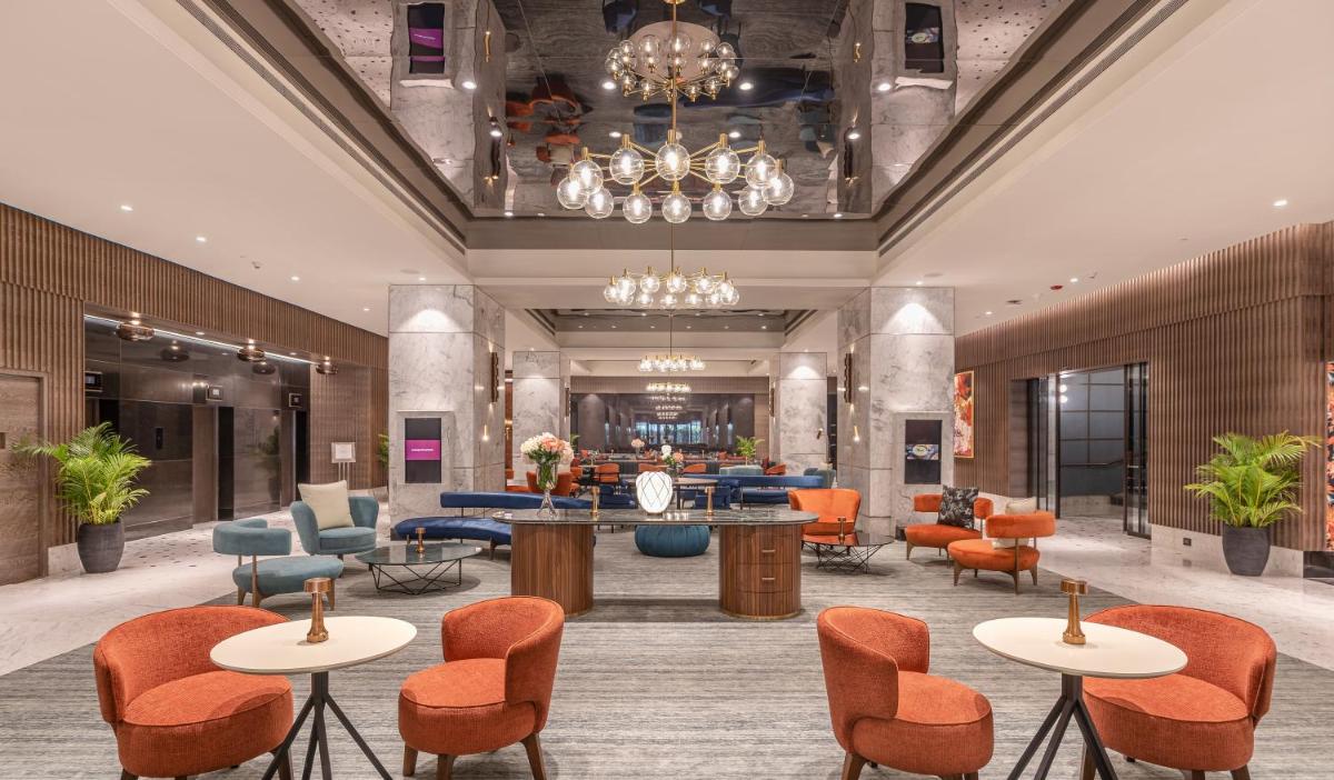 a lobby of a hotel with tables and chairs at President - IHCL SeleQtions in Mumbai a lobby of a hotel with tables and chairs at President - IHCL SeleQtions in Mumbai