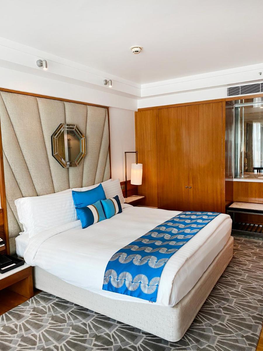 a hotel room with a large bed with blue pillows at InterContinental Marine Drive Mumbai by IHG in Mumbai