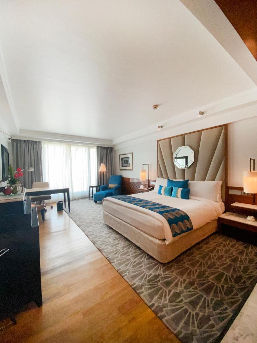a hotel room with a large bed and a desk at InterContinental Marine Drive Mumbai by IHG in Mumbai
