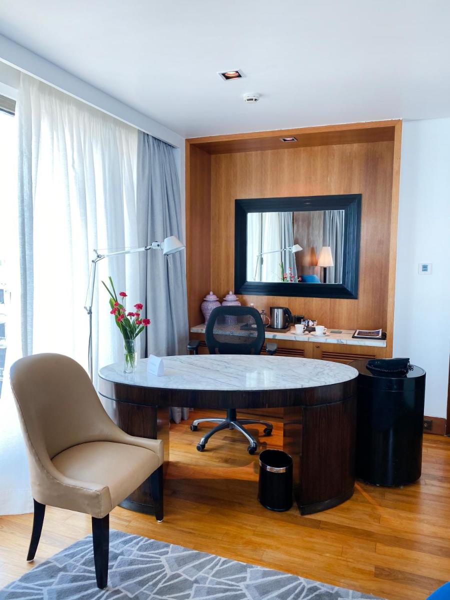 a room with a desk with a chair and a mirror at InterContinental Marine Drive Mumbai by IHG in Mumbai