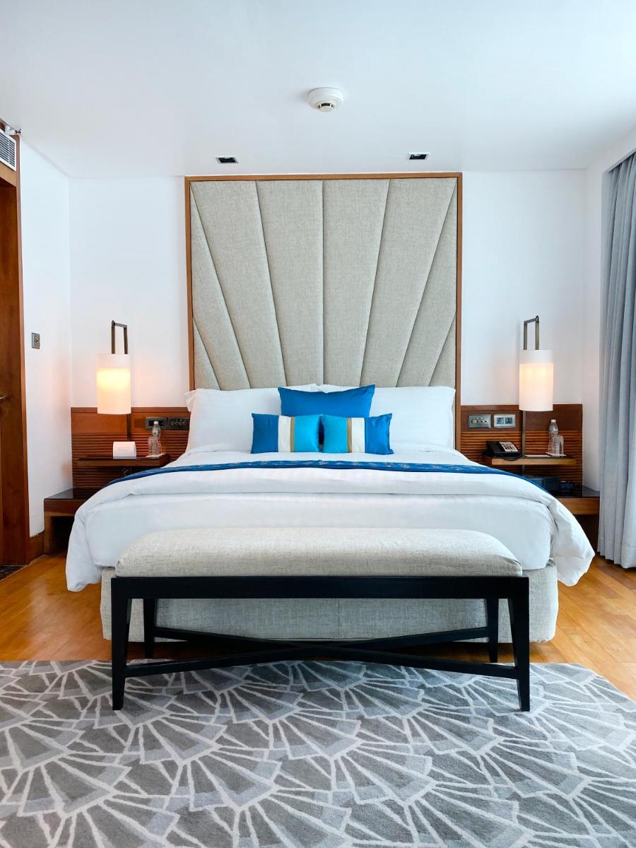 a bedroom with a large bed with blue pillows at InterContinental Marine Drive Mumbai by IHG in Mumbai