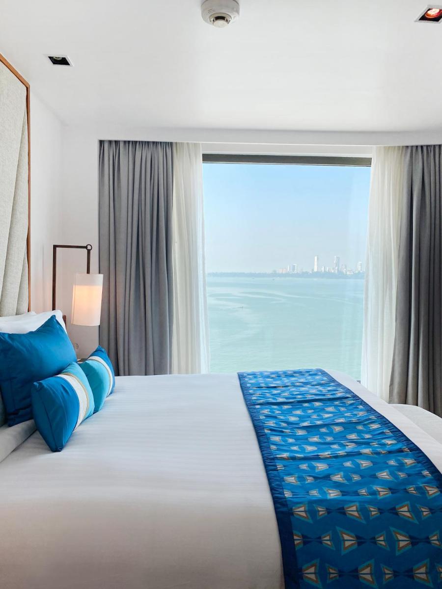 a bedroom with a large bed with a large window at InterContinental Marine Drive Mumbai by IHG in Mumbai
