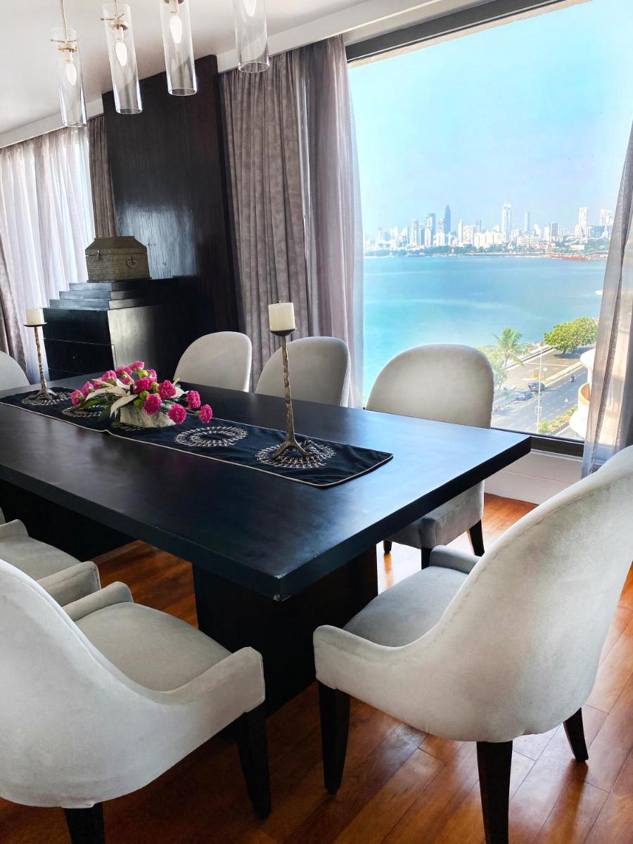 a dining room with a table and chairs and a large window at InterContinental Marine Drive Mumbai by IHG in Mumbai