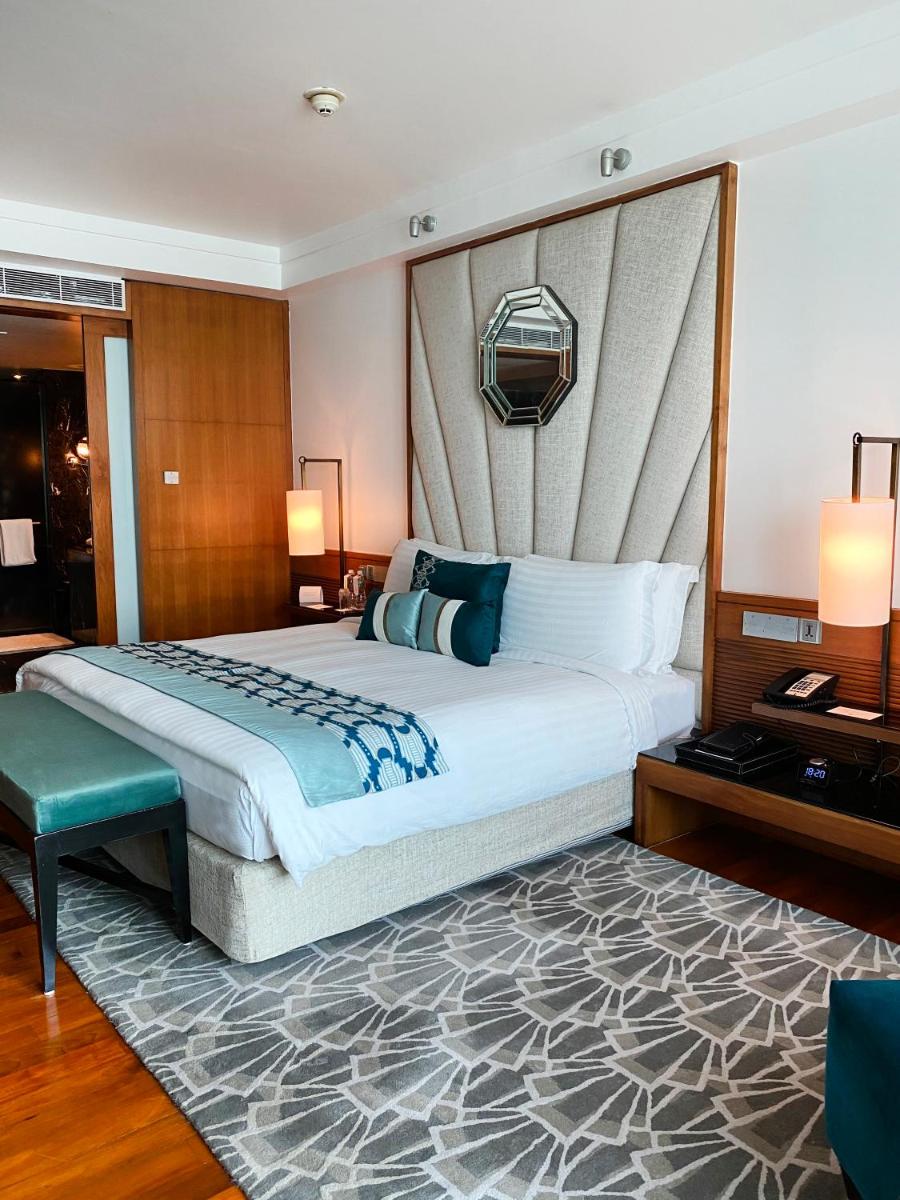 a bedroom with a large bed with a large headboard at InterContinental Marine Drive Mumbai by IHG in Mumbai