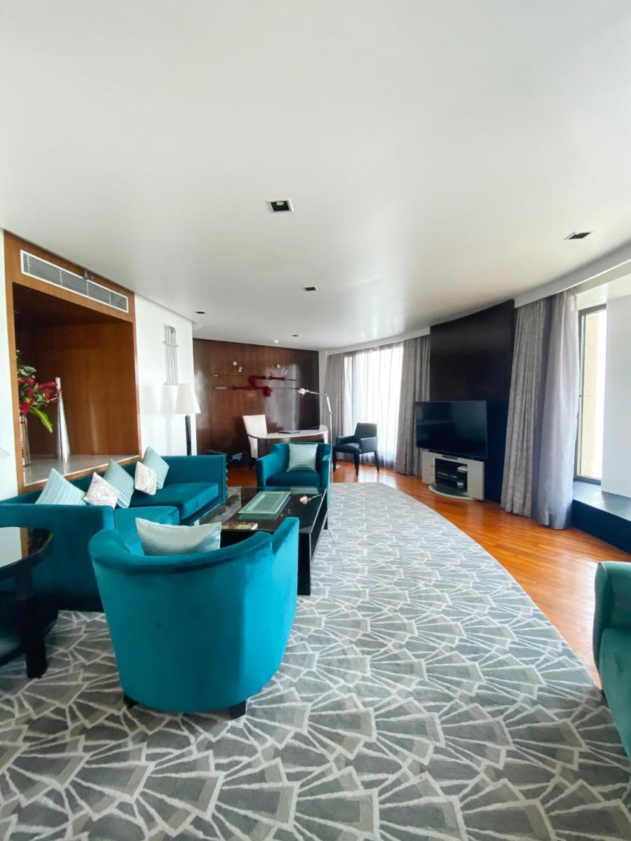 a living room with blue couches and a table at InterContinental Marine Drive Mumbai by IHG in Mumbai