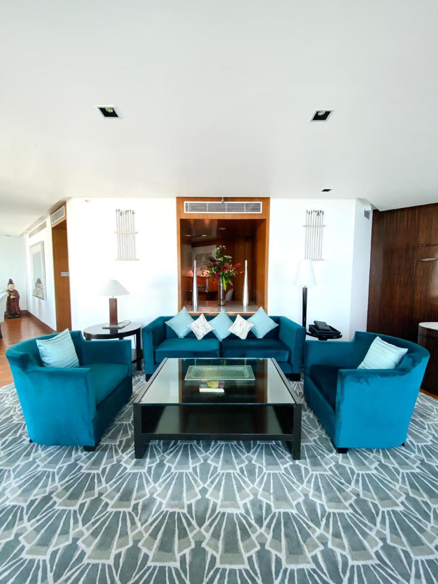 a living room with blue couches and a coffee table at InterContinental Marine Drive Mumbai by IHG in Mumbai