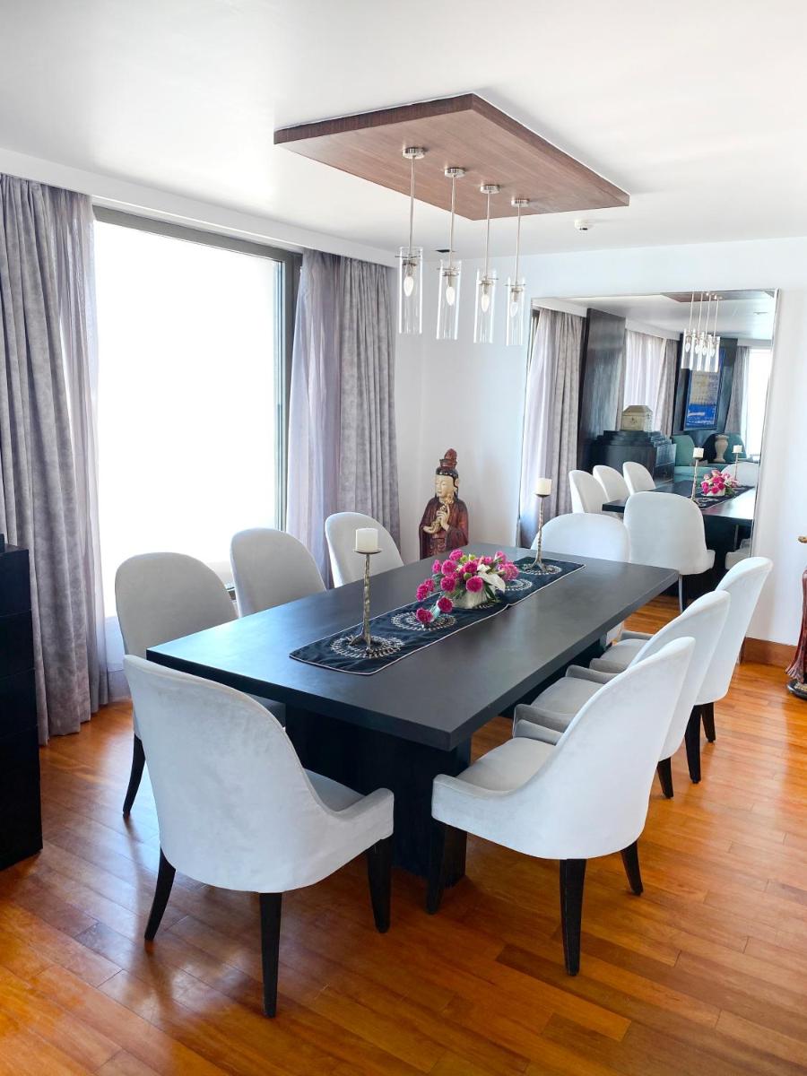 a dining room with a black table and white chairs at InterContinental Marine Drive Mumbai by IHG in Mumbai