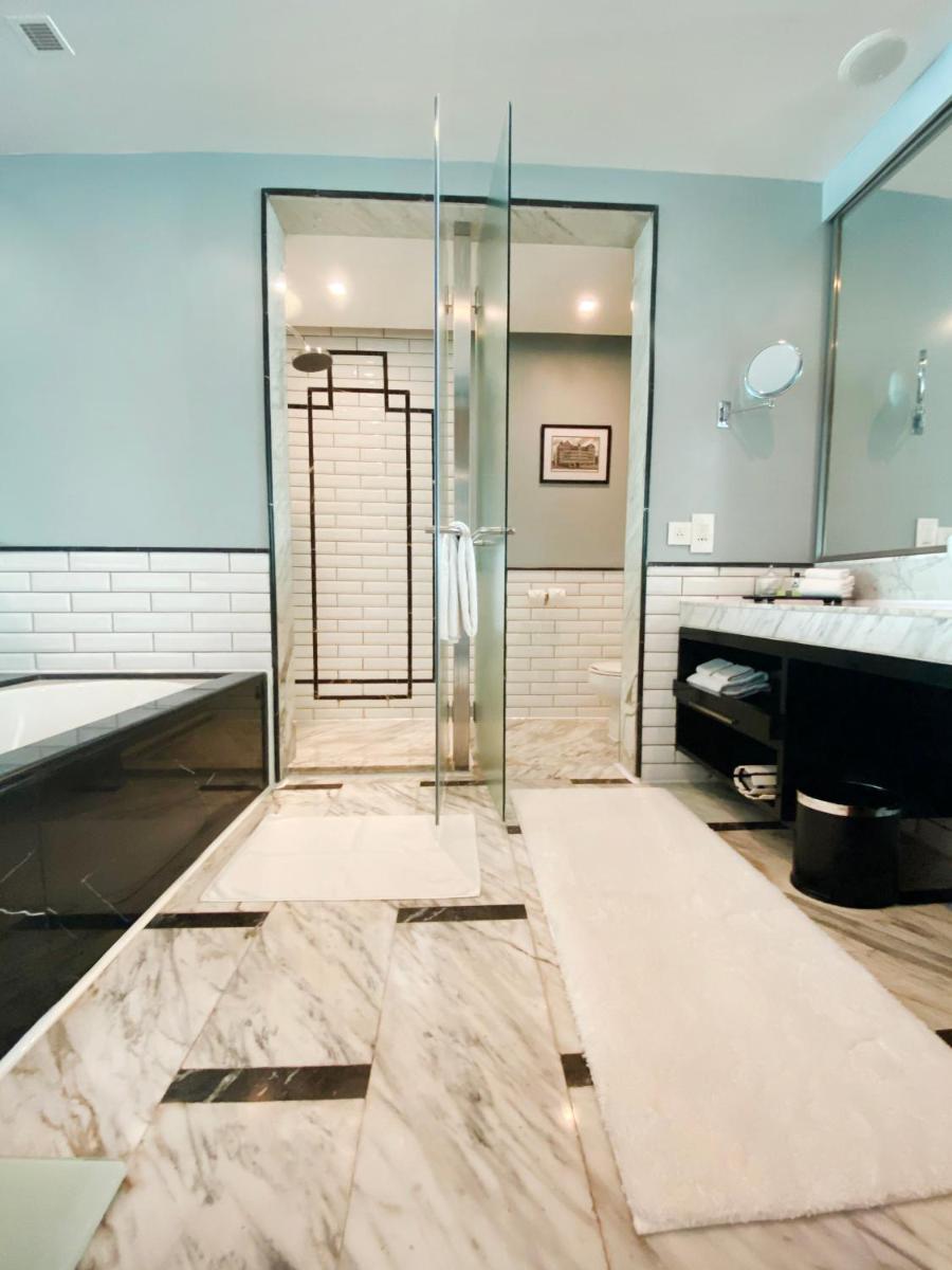 a bathroom with a shower and a tub and a sink at InterContinental Marine Drive Mumbai by IHG in Mumbai