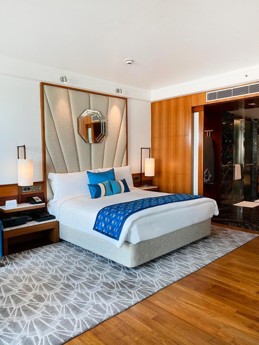 a bedroom with a large bed with blue pillows at InterContinental Marine Drive Mumbai by IHG in Mumbai