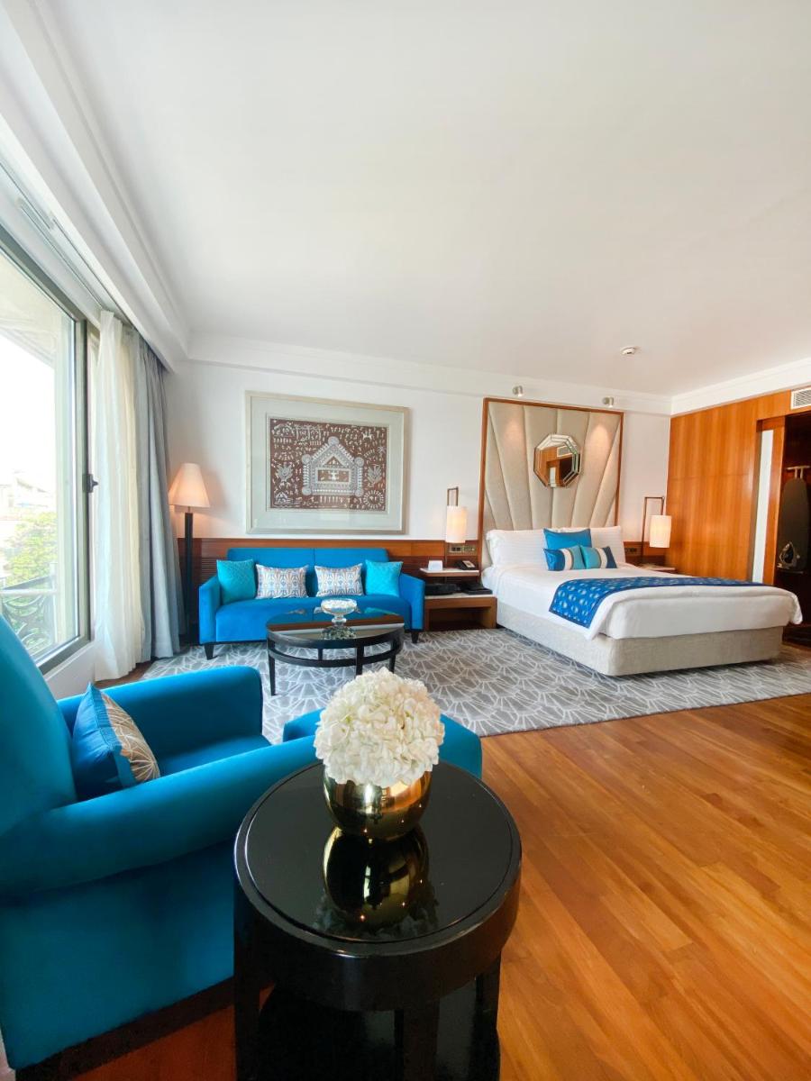 a living room with a bed and a blue couch at InterContinental Marine Drive Mumbai by IHG in Mumbai a living room with a bed and a blue couch at InterContinental Marine Drive Mumbai by IHG in Mumbai