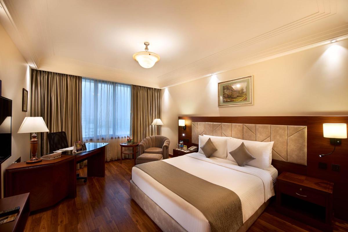 a hotel room with a bed and a desk at The Accord Metropolitan in Chennai
