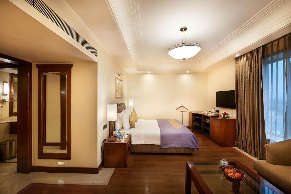 a hotel room with a bed and a couch at The Accord Metropolitan in Chennai