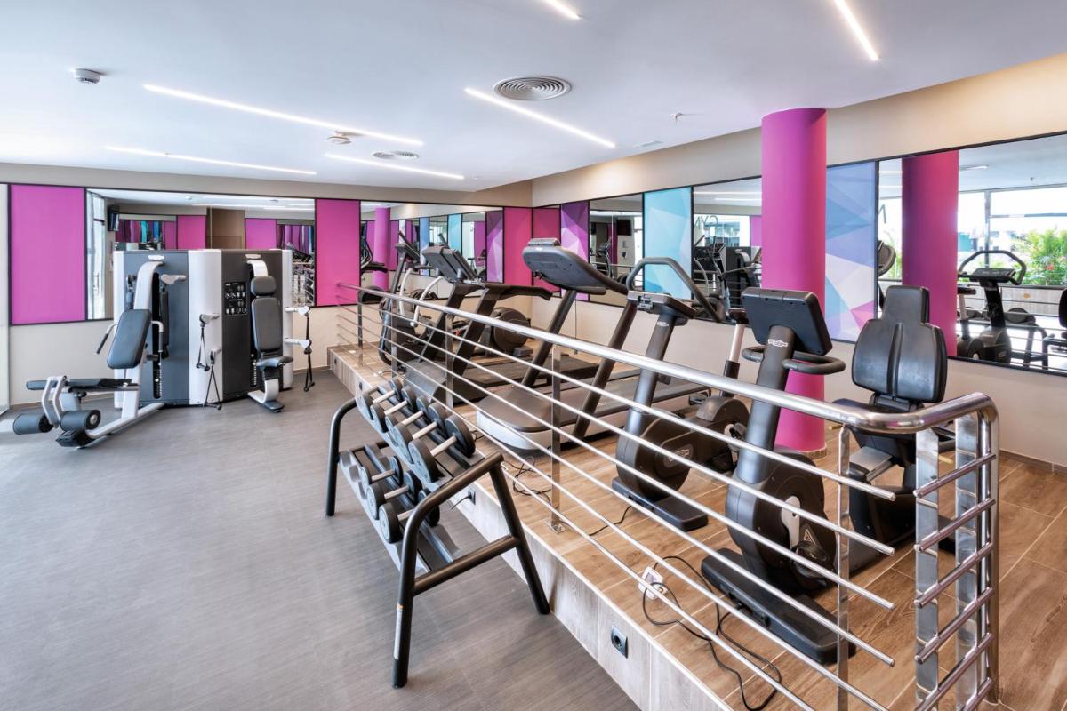 un gimnasio con cintas de correr y máquinas elípticas en Hotel Riu Palace Jandia, en Playa de Jandía