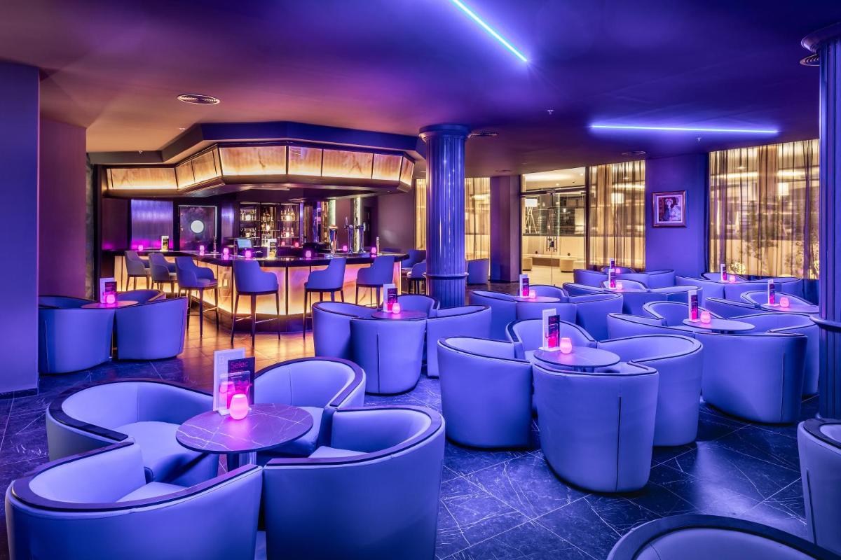 un restaurante con mesas y sillas azules y un bar en Hotel Riu Palace Jandia, en Playa de Jandía
