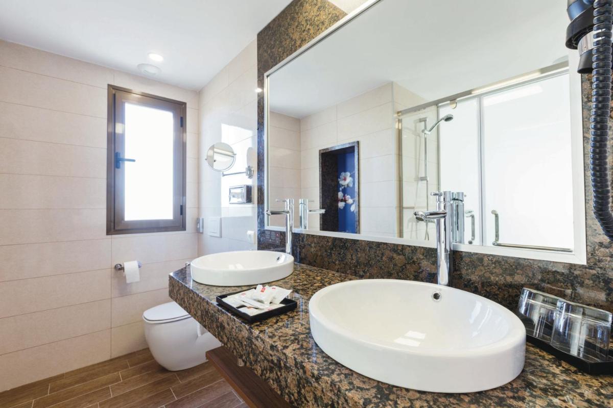 Un baño con dos lavabos y un inodoro. en Hotel Riu Bravo - 0'0 All Inclusive, en Playa de Palma