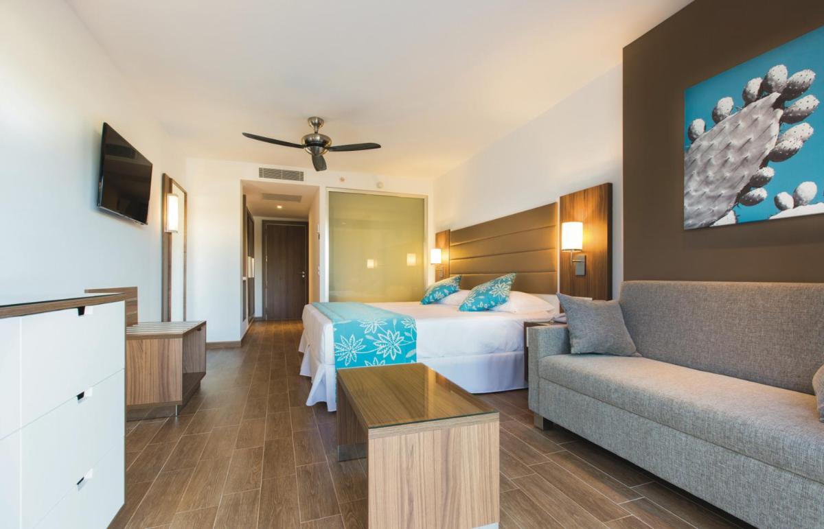 una habitación de hotel con una cama y un sofá en Hotel Riu Bravo - 0'0 All Inclusive, en Playa de Palma