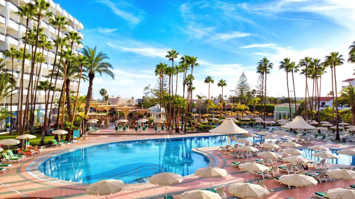 una piscina en un resort con sillas y sombrillas en Bull Eugenia Victoria & SPA, en Playa del Inglés