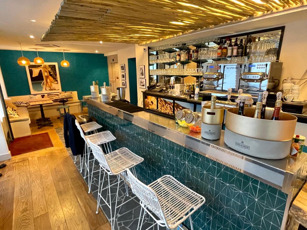 un restaurant avec un comptoir à trois tabourets dans l'établissement La Finca Hôtel & Spa, à Paris