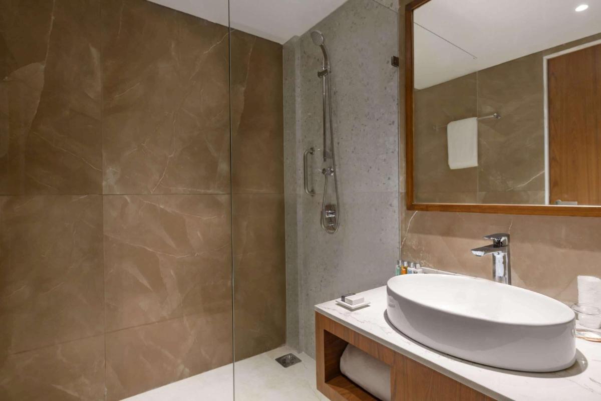 a bathroom with a sink and a shower at Hawthorn Suites by Wyndham Dwarka in Dwarka a bathroom with a sink and a shower at Hawthorn Suites by Wyndham Dwarka in Dwarka