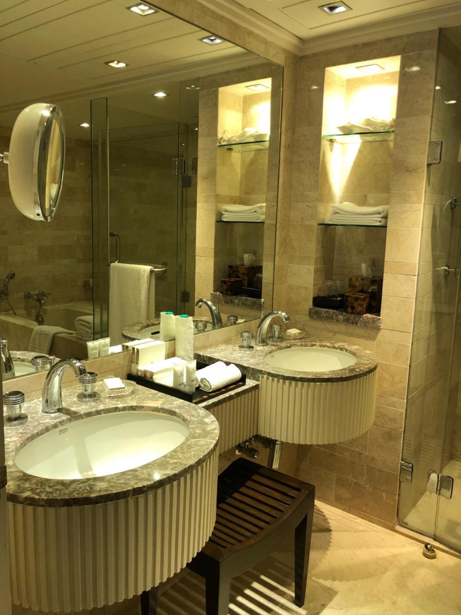 a bathroom with two sinks and a large mirror at The Leela Mumbai in Mumbai a bathroom with two sinks and a large mirror at The Leela Mumbai in Mumbai