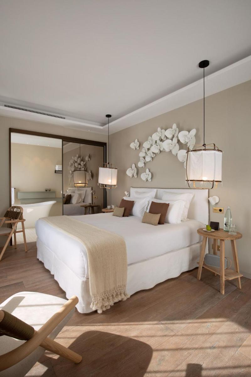 une chambre avec un grand lit blanc et une chaise dans l'établissement Misincu, à Cagnano