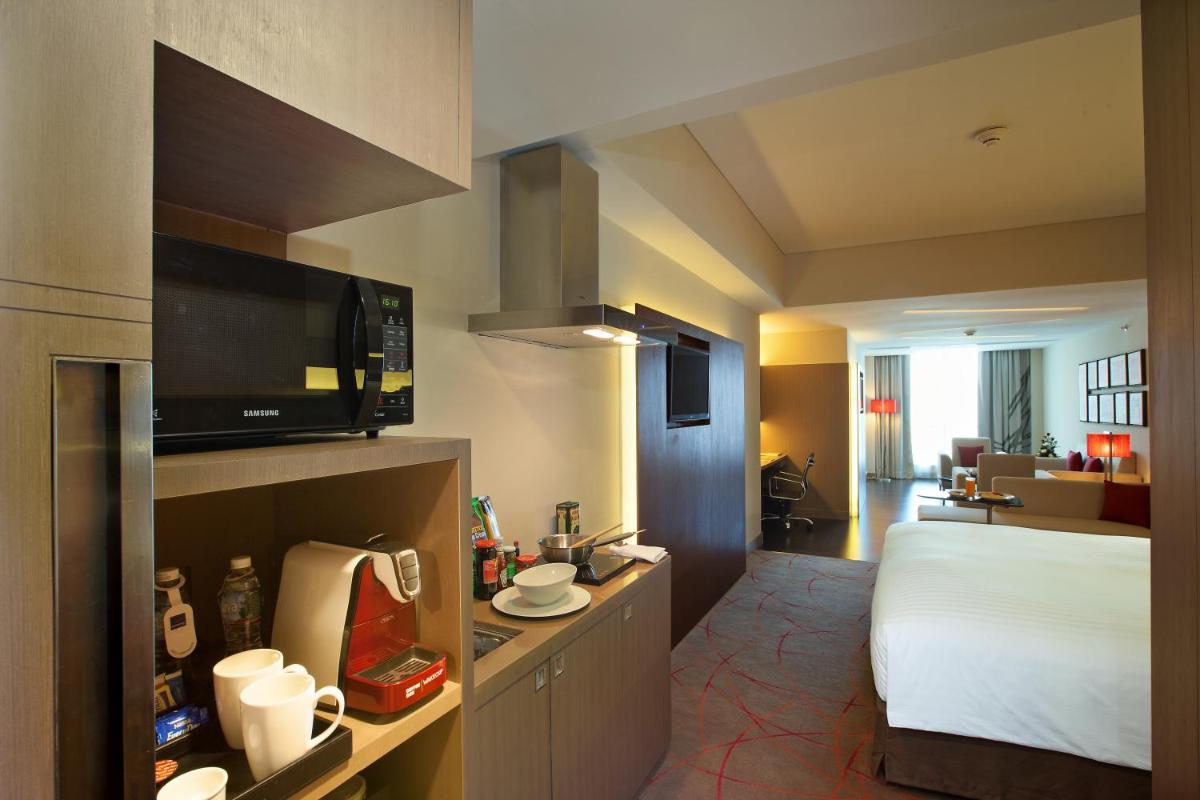 a hotel room with a bed and a kitchen at Novotel Ahmedabad in Ahmedabad