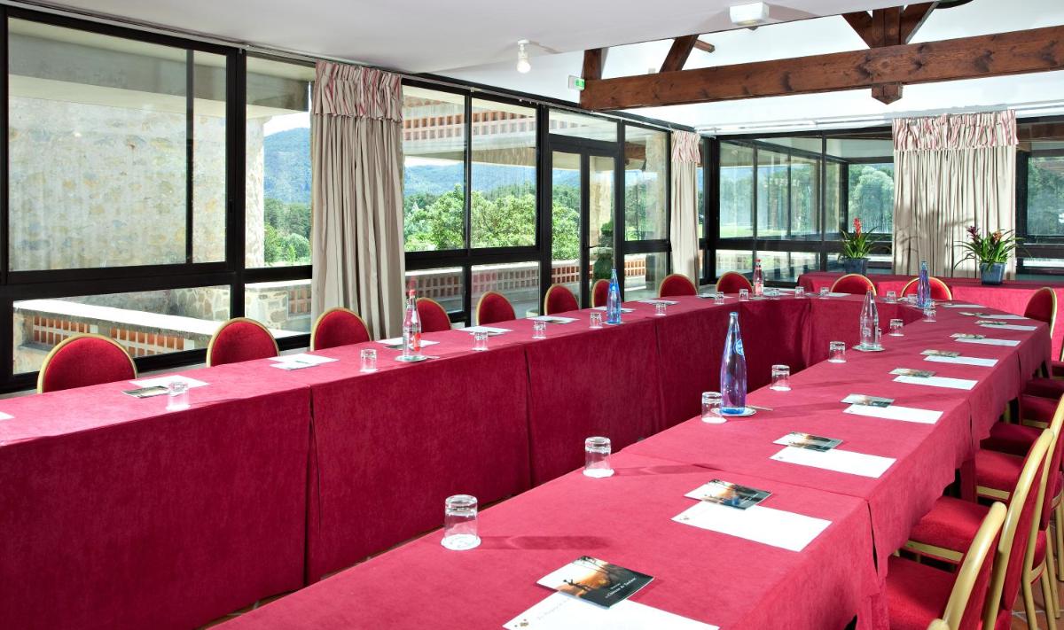 - une rangée de tables dans une pièce avec des chaises rouges et des fenêtres dans l'établissement Château et Golf De Taulane, à La Martre 70 autres photos