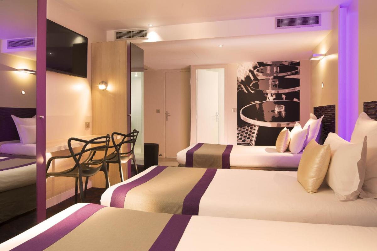 une chambre d'hôtel avec deux lits et une table dans l'établissement Hôtel Brésil Opéra SPA, à Paris 68 autres photos