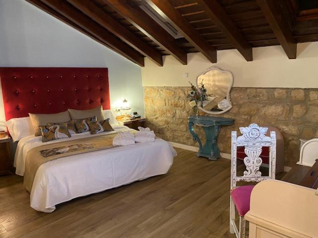 Un dormitorio con una cama grande y una pared de piedra. en HOTEL CASABLANCA BOUTIQUE, en Linares