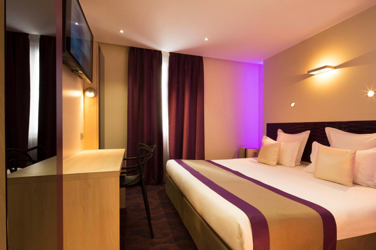 une chambre d'hôtel avec un lit à éclairage violet dans l'établissement Hôtel Brésil Opéra SPA, à Paris