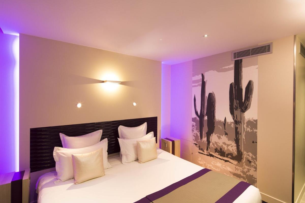 - une chambre avec un lit orné d'une peinture de cactus sur le mur dans l'établissement Hôtel Brésil Opéra SPA, à Paris