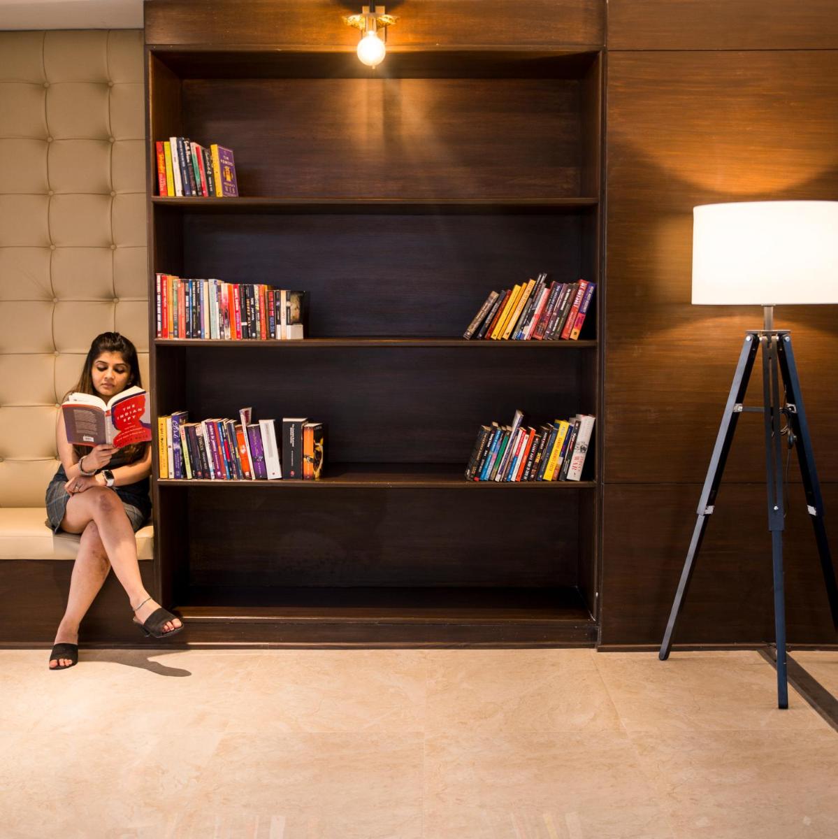 a woman sitting on a shelf reading a book at Grand Mercure Bengaluru at Gopalan Mall - An Accor Brand in Bengaluru a woman sitting on a shelf reading a book at Grand Mercure Bengaluru at Gopalan Mall - An Accor Brand in Bengaluru
