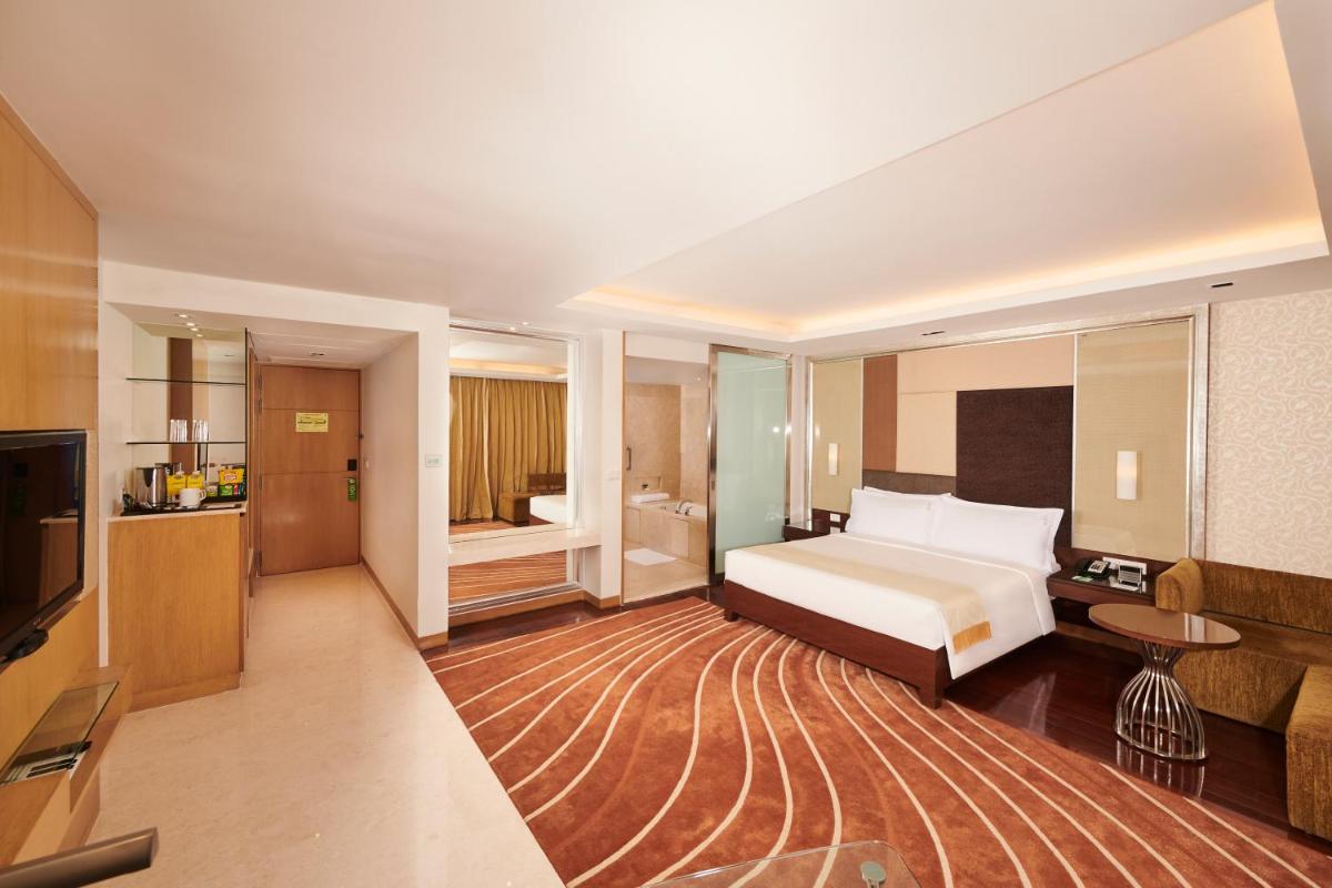 a hotel room with a bed and a television at Holiday Inn Mumbai International Airport by IHG in Mumbai a hotel room with a bed and a television at Holiday Inn Mumbai International Airport by IHG in Mumbai