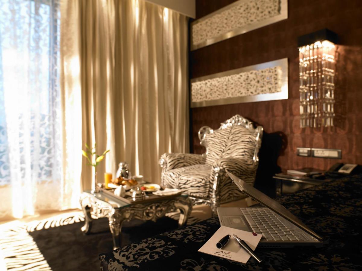 a living room with a laptop computer on a chair at The Zuri Whitefield Bengaluru in Bengaluru
