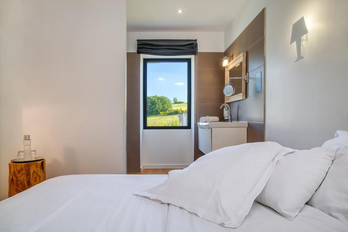 Un ou plusieurs lits dans un hébergement de l'établissement Le Domaine de Baulieu, Singuliers Hotels