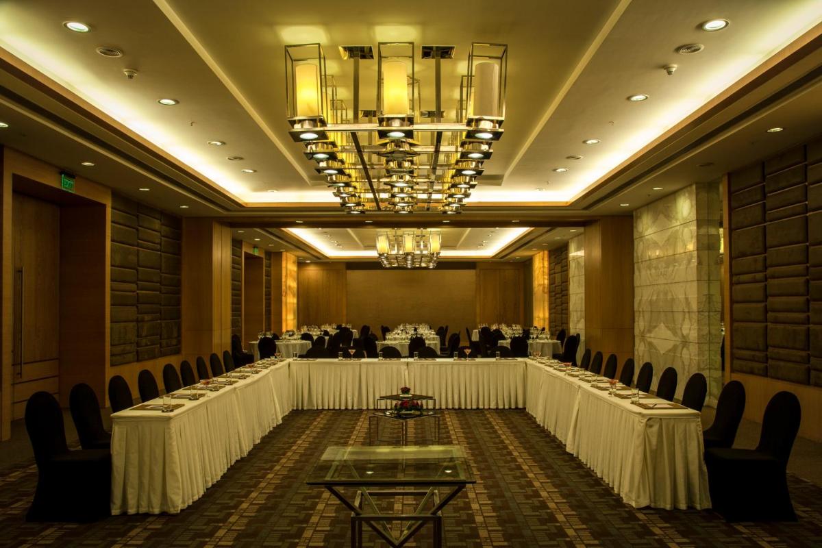 a banquet hall with tables and chairs and a chandelier at Radisson Blu Hotel Pune Kharadi in Pune