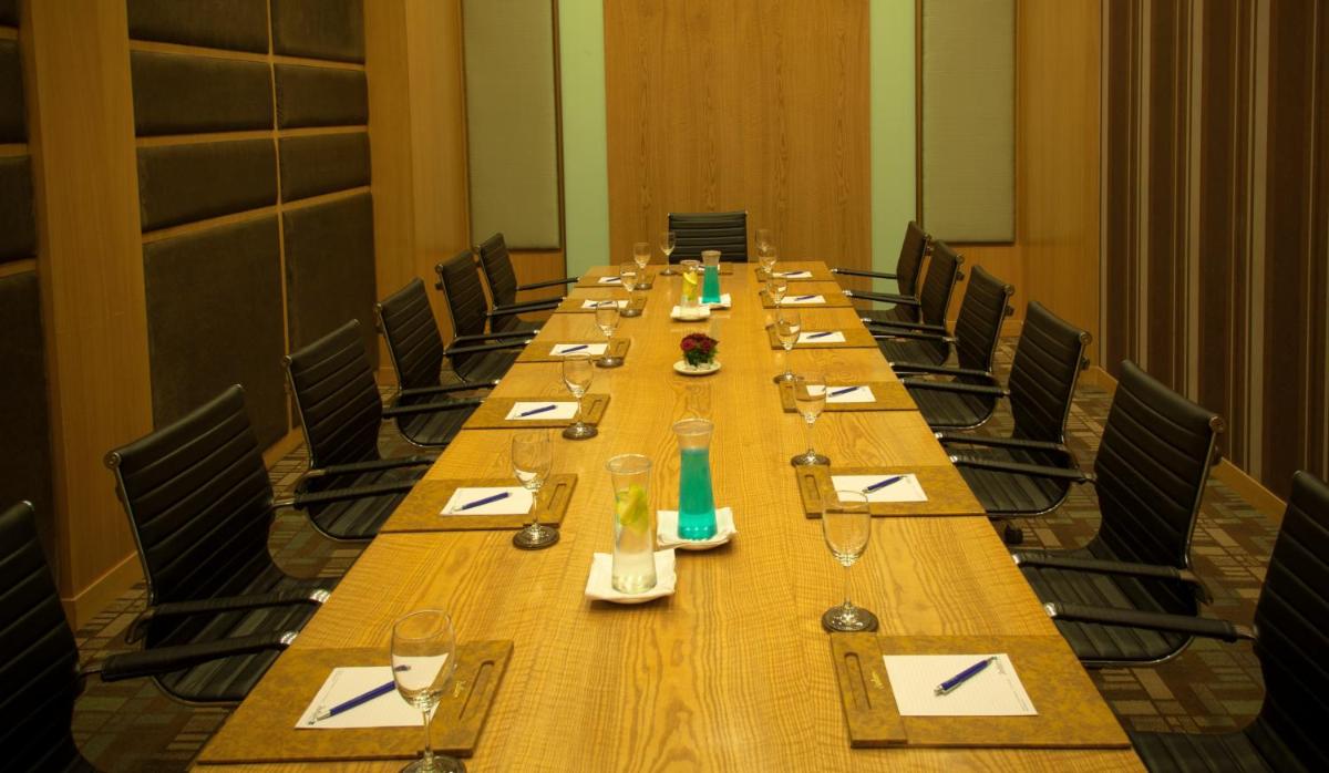 a long wooden table in a conference room at Radisson Blu Hotel Pune Kharadi in Pune